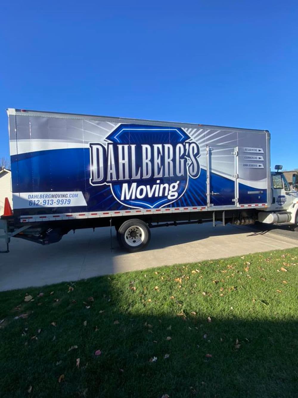 Dahlberg's Moving truck with blue and silver branding parked outdoors.
